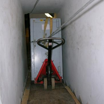 Transport kasy pancernej po schodach w wąskim korytarzu